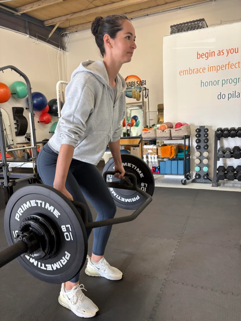 Woman doing strength training at Pilates studio in Boulder with reformers